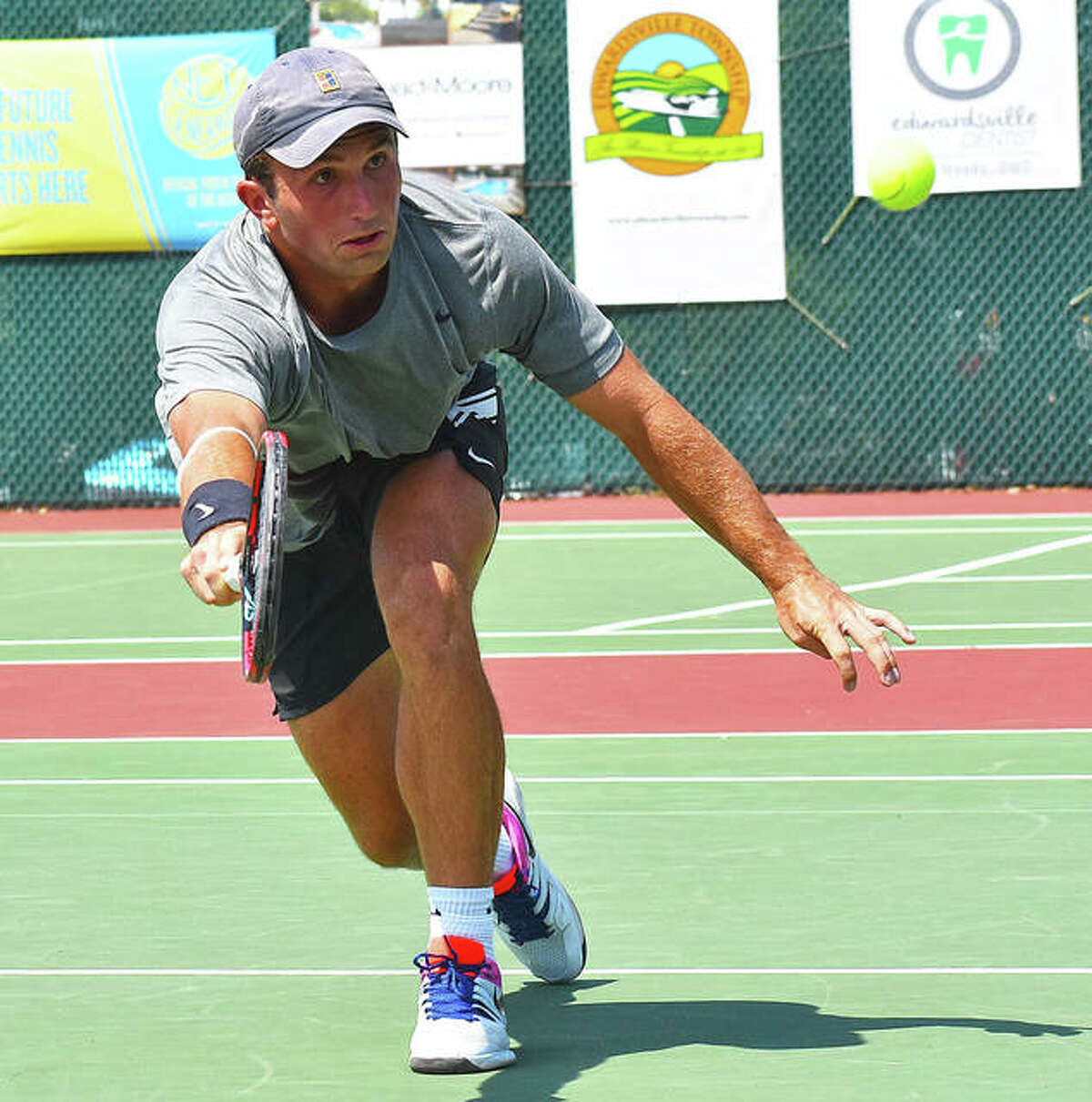 Preston Touliatos hits a shot at the net during his first-round match against Carson Haskins in the qualifying tournament of the Edwardsville Futures.