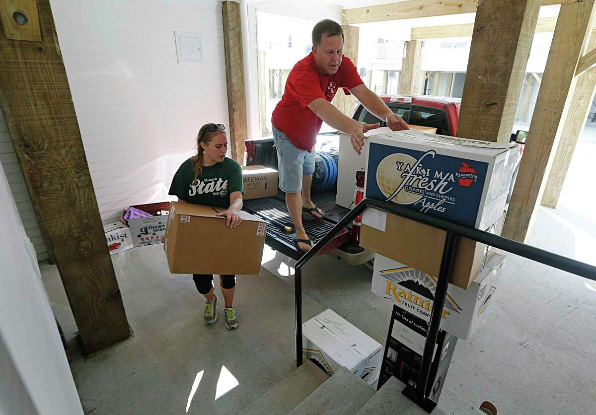 Katie Schmitz left, with the help of her father Terry Schmitz right, moves into the Cedars at Carver Park mixed income housing development in 2015.