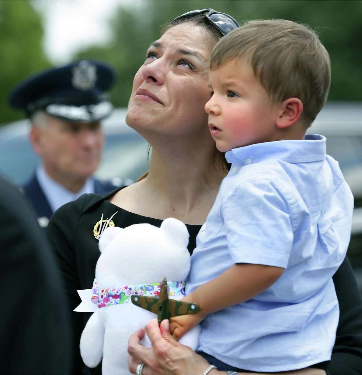 Sammi Bonney, left, holds her son Ben Bonney, 2, great grandson of Oliver "Ollie" Crawford, who holds a toy Curtiss P-40 Warhawk plane, as four F-16s pass overhead at Crawford's funeral at Fort Sam Houston National Cemetery on Monday.