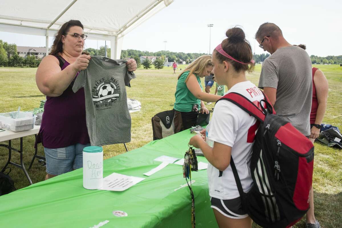 Karen Scarborough, left, helps customers with purchasing merchandise during the Inaugural Bailee Mantei Foundation 3v3 Soccer Tournament at the Midland Soccer Complex on Saturday, July 3, 2019. Proceeds from the event will be put into the foundation's fund for annual scholarships in Bailee Mantei's memory. "The foundation's going to benefit a lot from this," said Scarborough, a friend of the Mantei family. (Danielle McGrew Tenbusch/for the Daily News)