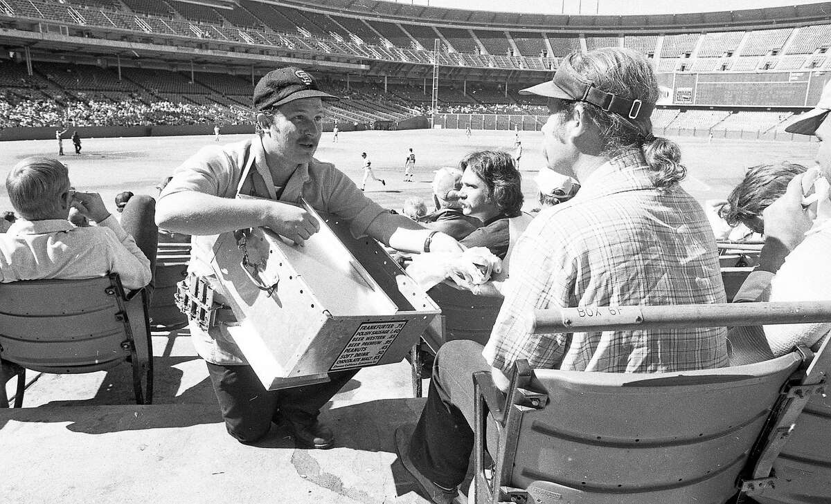 1976年9月13日:在旧金山巨人队的比赛现场，一个小贩在几乎空无一人的烛台公园里卖热狗。