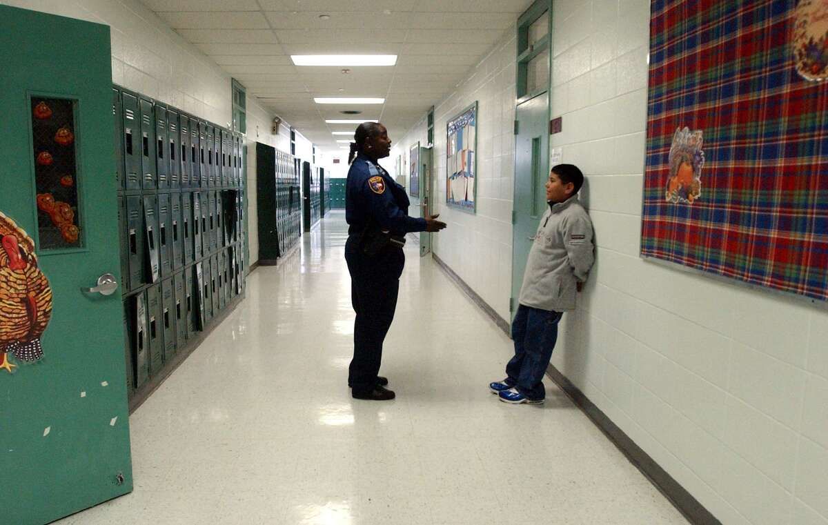 Officer Rogena Reed in 2002, talking with 7th grader Robert Garcia in a school hallway in Edgewood ISD. (Robert McLeroy/Staff)