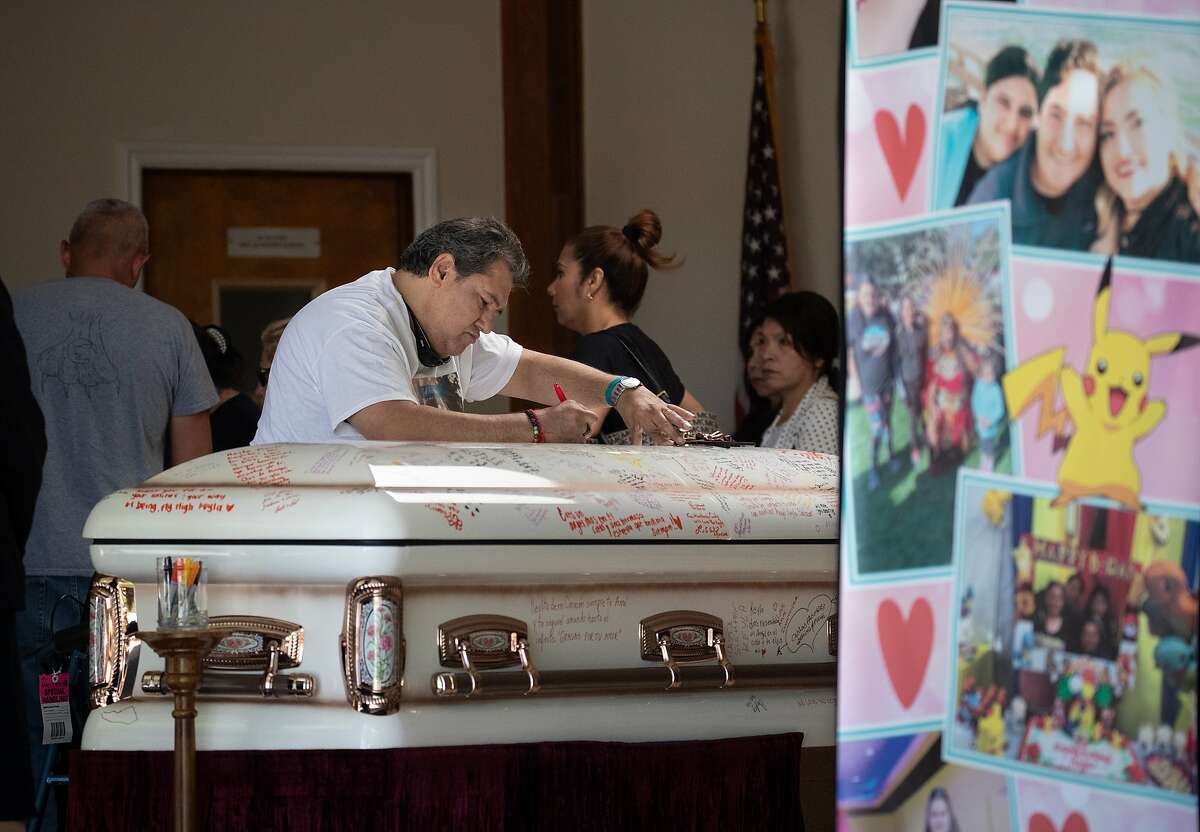 A funeral participant writes a message on the casket as friends and family gather to honor the life of Keyla Salazar, 13, a Gilroy shooting victim, at Our Lady of Guadalupe on Tuesday, Aug. 6, 2019, in San Jose, Calif.