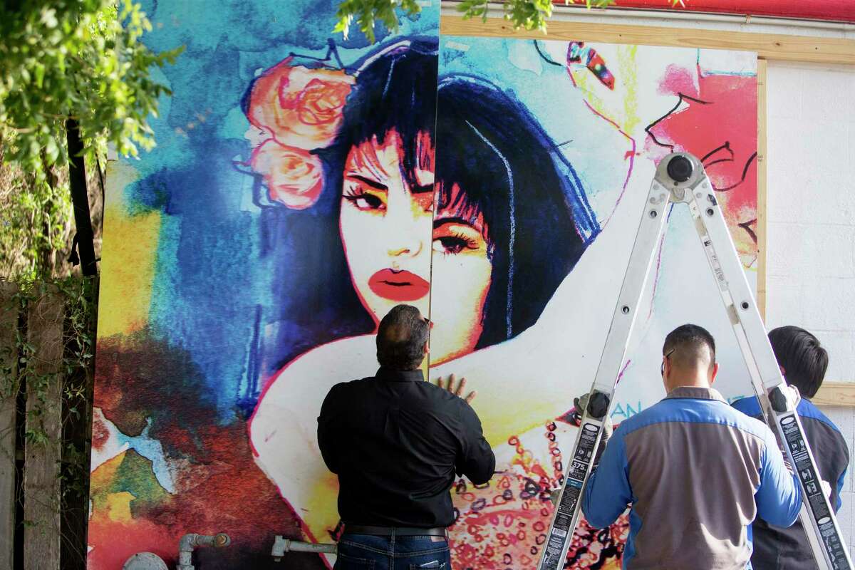 In this Tuesday, July 30, 2019 photo, from left, Ray Hernandez, David Dominguez and Alex Rodriguez, with Iconic Signs Group, install a new Selena mural on the exterior of the Food Store in the Molina neighborhood of Corpus Christi, Texas. The previous mural was painted by West Oso High School students in 1995 as a neighborhood tribute to Selena Quintanilla-Perez. (Rachel Denny Clow/Corpus Christi Caller-Times via AP)
