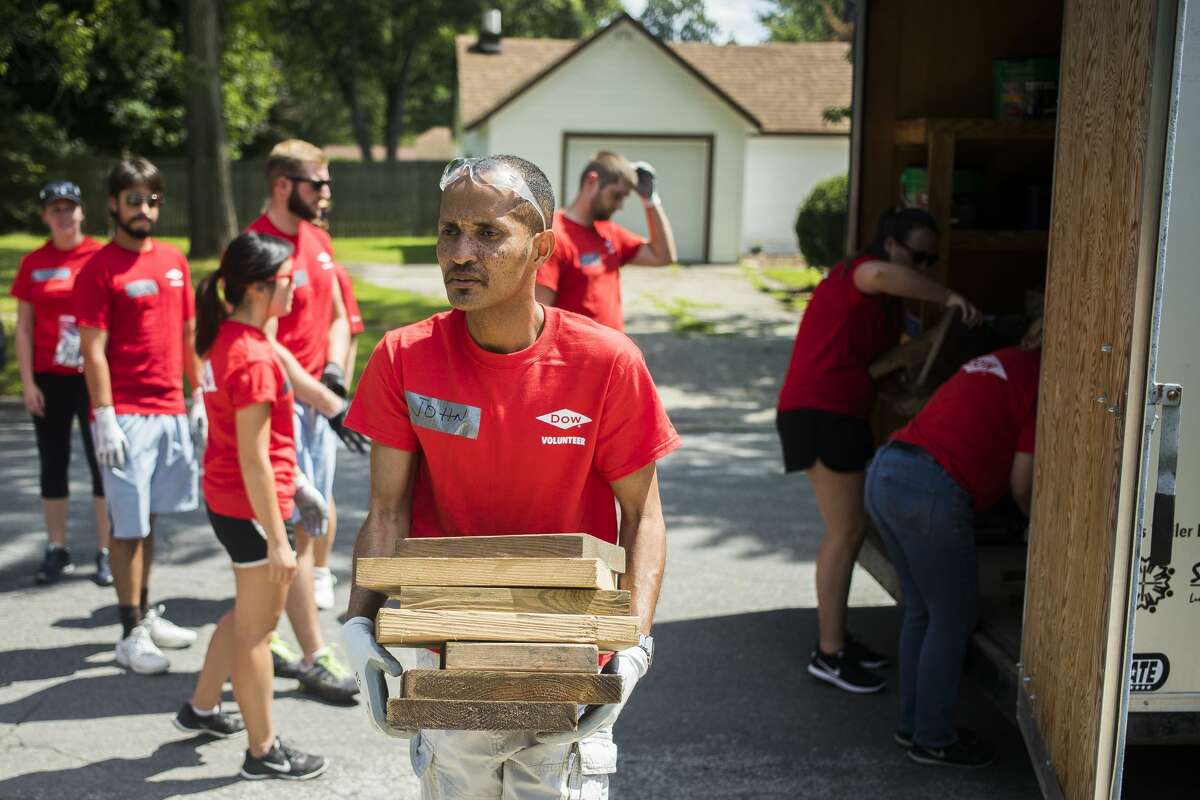 John Tsaras carries supplies while volunteering for Midland County Habitat for Humanity's Neighborhood Revitalization Initiative on Wednesday, Aug. 7, 2019. (Katy Kildee/kkildee@mdn.net)