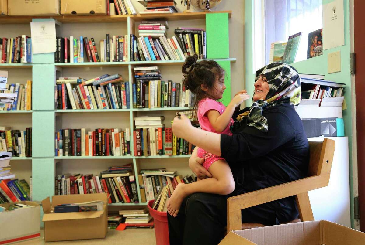 Halide Altikardes (right) plays with her granddaughter, Nil Oguz, at Dead Tree Books while Altikardes' son was shopping for books.
