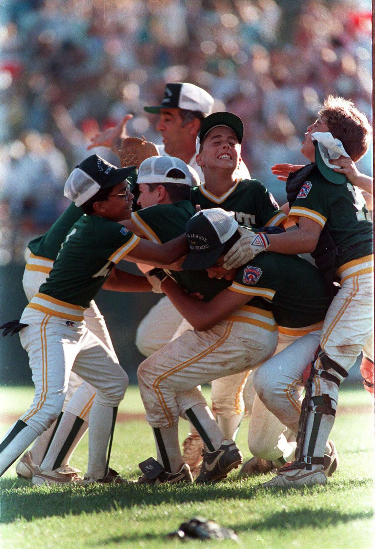 Members of the Trumbull,Conn., Little League team mob winning pitcher Chris Drury, second from left with cap askew, Aug. 26, 1989 as they celebrate on the field at Williamsport, Pa. Connecticut had just defeated Taiwan in the championship game of the Little League World Series. In background is Connecticut coach Bob Zullo.