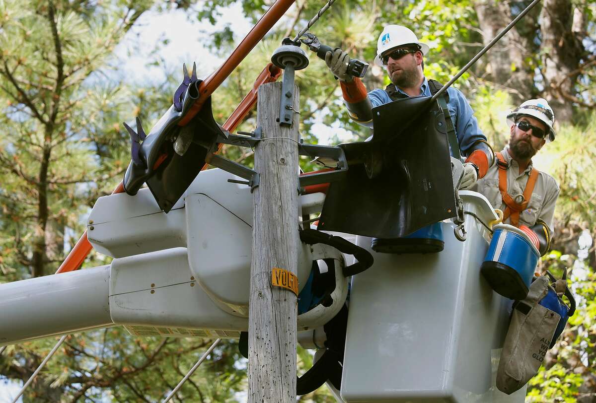 PG&E's Taylor Flosi and Rob Thomas, (back) repair a power line that had come loose from an insulator which was discovered during patrols in the area as PG&E performed a public safety power shutoff drill around Foresthill, Ca. on Thurs. August 8, 2019. Helicopters and trucks, are used in a trial run for how it will inspect power lines before turning them on after a shut down.