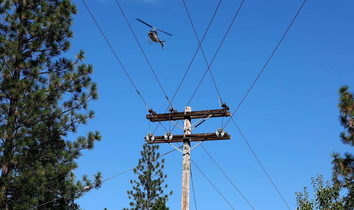 A PG&E helicopter flies 300 feet above inspecting power lines, as PG&E performs a public safety power shutoff drill around Foresthill, Ca. on Thurs. August 8, 2019, Helicopters and trucks, are used in a trial run for how it will inspect power lines before turning them on after a shut down.