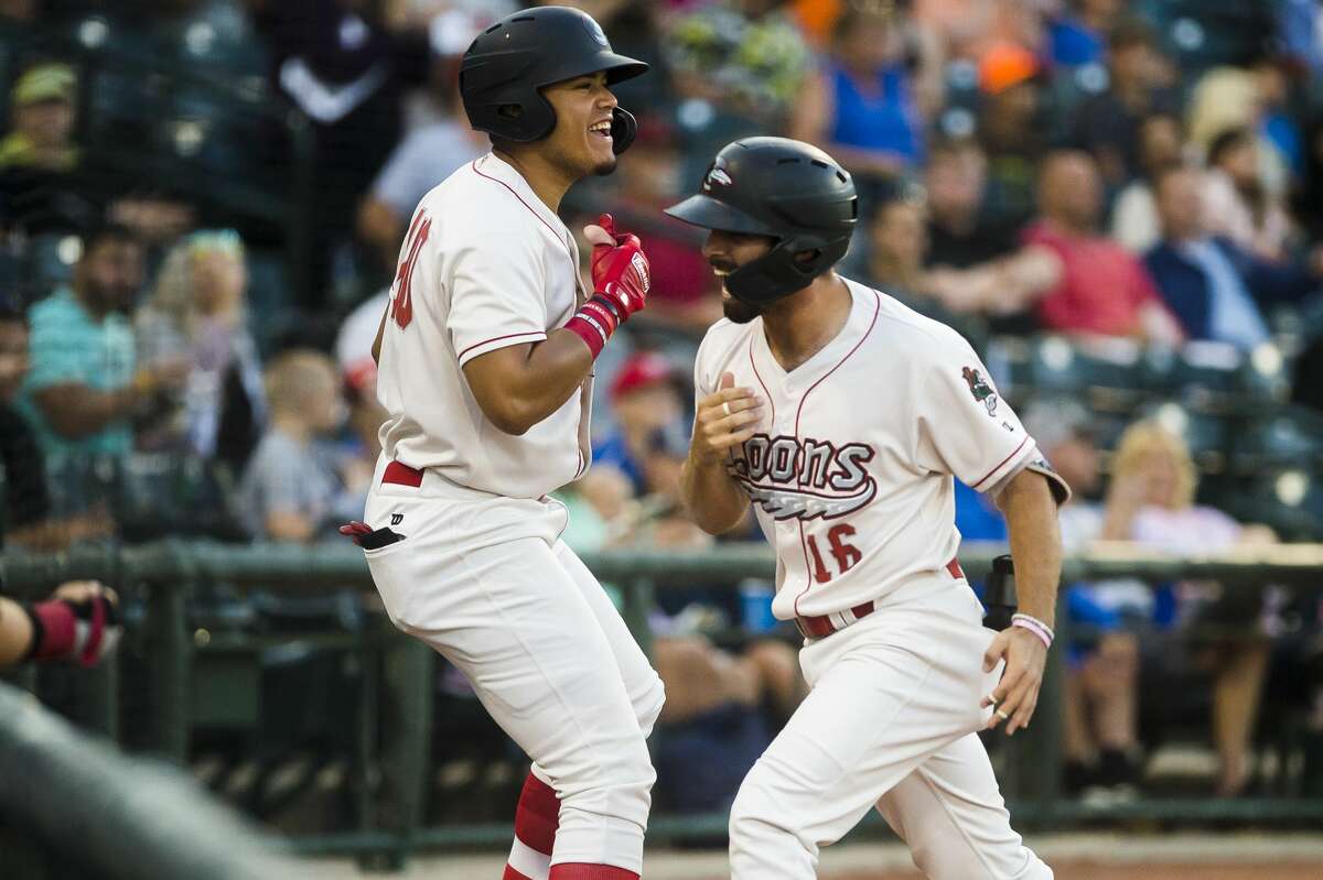 Great Lakes Loons third baseman Luke Heyer, right, high-fives right fielder Romer Cuadrado, left, after hitting a home run during a game against the Lake County Captains on Thursday, Aug. 8, 2019 at Dow Diamond. (Katy Kildee/kkildee@mdn.net)