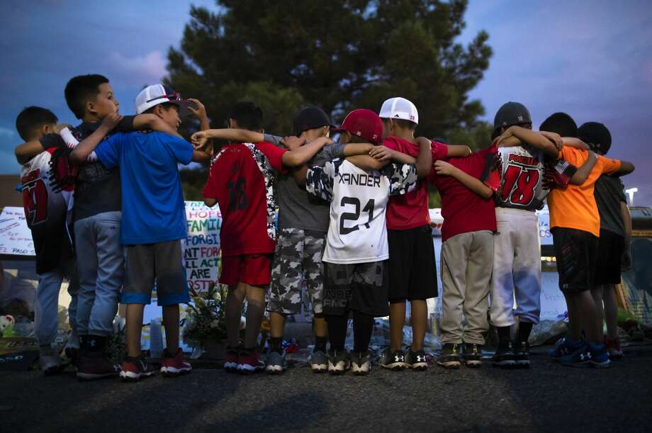 Xsquad and the Hit Squad baseball teams gather at a makeshift memorial to honor the victims of the Walmart shooting in El Paso. Photo: Marie D. De Jesús/Staff Photographer