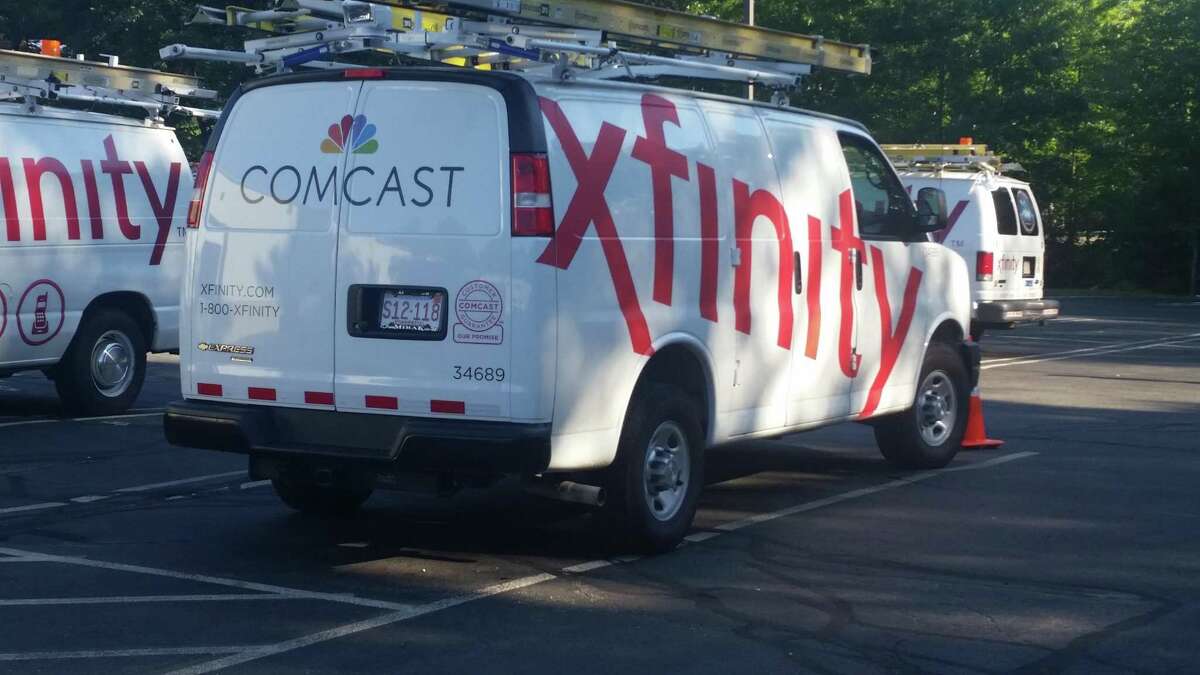 FILE - In this Sept. 17, 2015, file photo, Comcast trucks are parked in a lot in the company's Westford, Mass. operations center. Cable companies have poured millions into new tools and hires to try to de-agonize the process of getting cable TV, internet or phone service. It’s part of a years-long effort to try to assuage customers as the specter of “cord-cutting” _ dumping cable for Netflix and the like _ haunts the industry. (AP Photo/Tali Arbel, File)