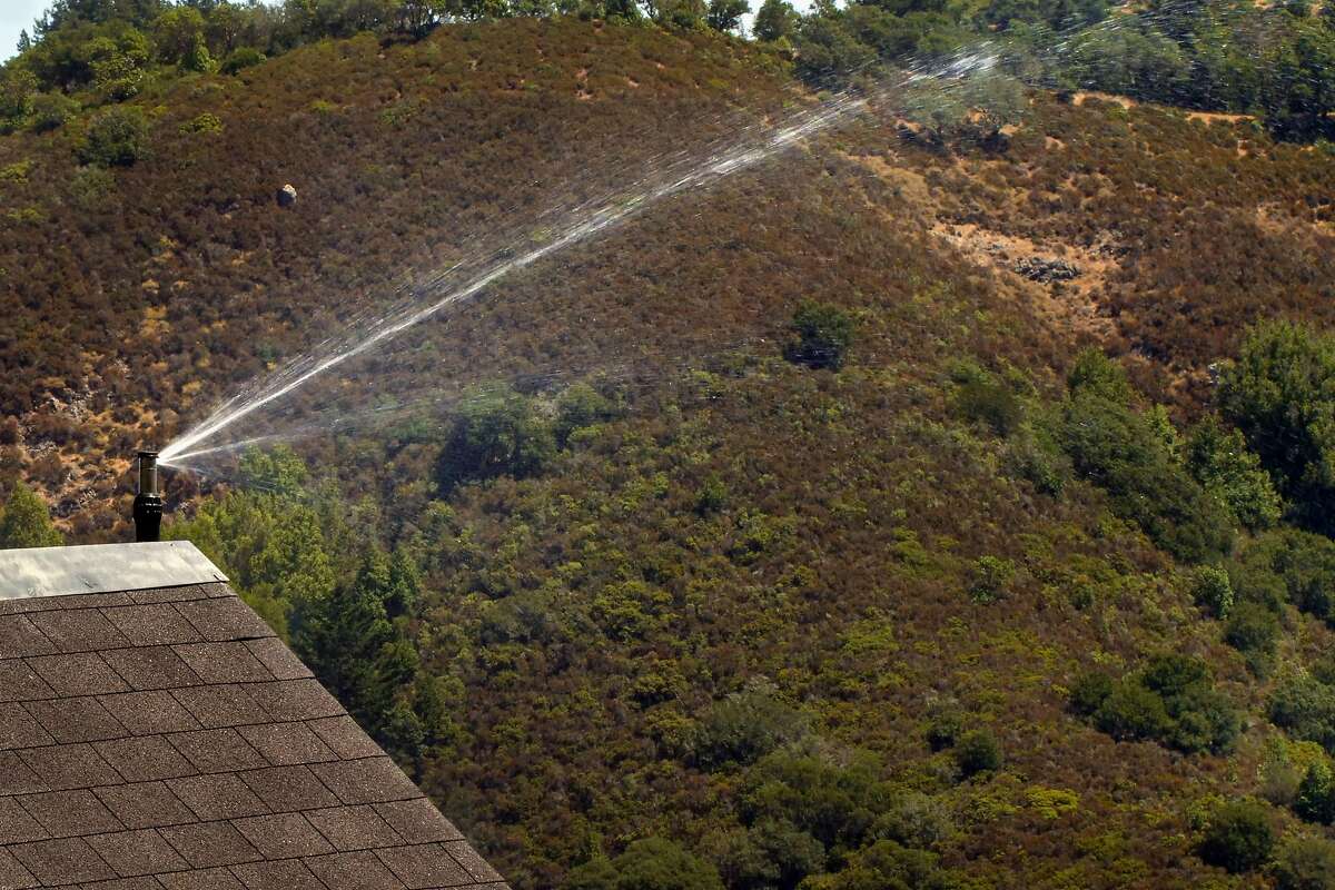 The exterior fire sprinkler system is tested by Frontline Wildfire Defense Systems is tested at the Cohen residence, Wednesday August 7, 2019, at their home in Mill Valley, Ca. Homeowners in fire-prone areas are taking extra precations for insurance and to protect their homes.