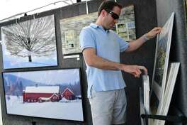 Jim Poucher of Fairfield looks at photoraphs by Ron Lake of Westport during the SoNo Arts Festival on Aug. 3 in Norwalk.
