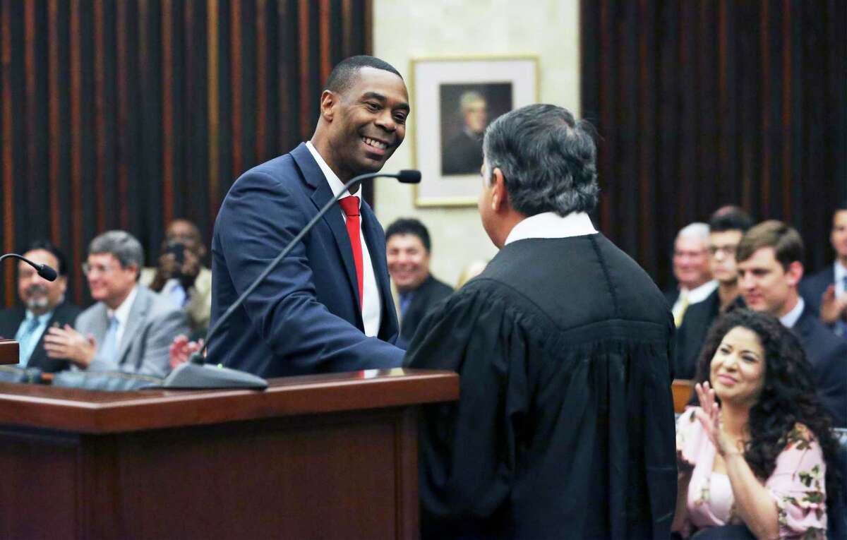 Jason Pulliam takes a handshake after he is sworn in as the newest federal judge by Chief U.S. District Judge Orlando Garcia at the John H. Wood Federal Courthouse on August 9, 2019.