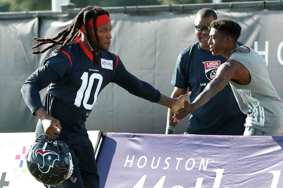 Houston Texans wide receiver DeAndre Hopkins (10) slaps hands with a fan as he runs to practice during training camp at the Methodist Training Center on Aug. 10, 2019, in Houston.