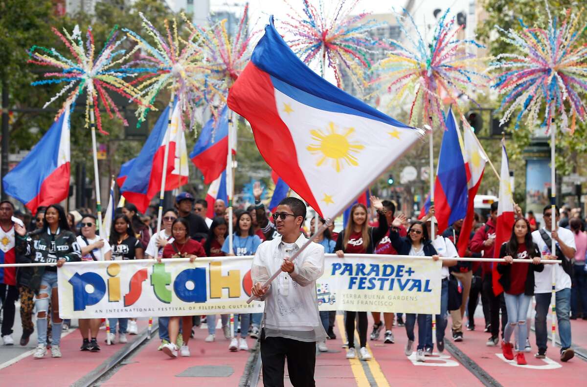 Joemar Olit waves the Philippines national flag as he leads the Pistahan parade down Market Street to the festival celebrating Filipino culture at Yerba Buena Gardens in San Francisco, Calif. on Saturday, Aug. 10, 2019.
