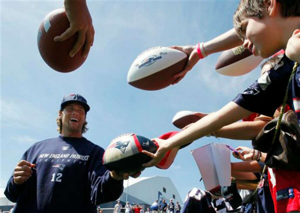 New England Patriots' Tom Brady signs autographs during NFL football training camp, Saturday, July 31, 2010, in Foxborough, Mass. (AP Photo/Michael Dwyer)