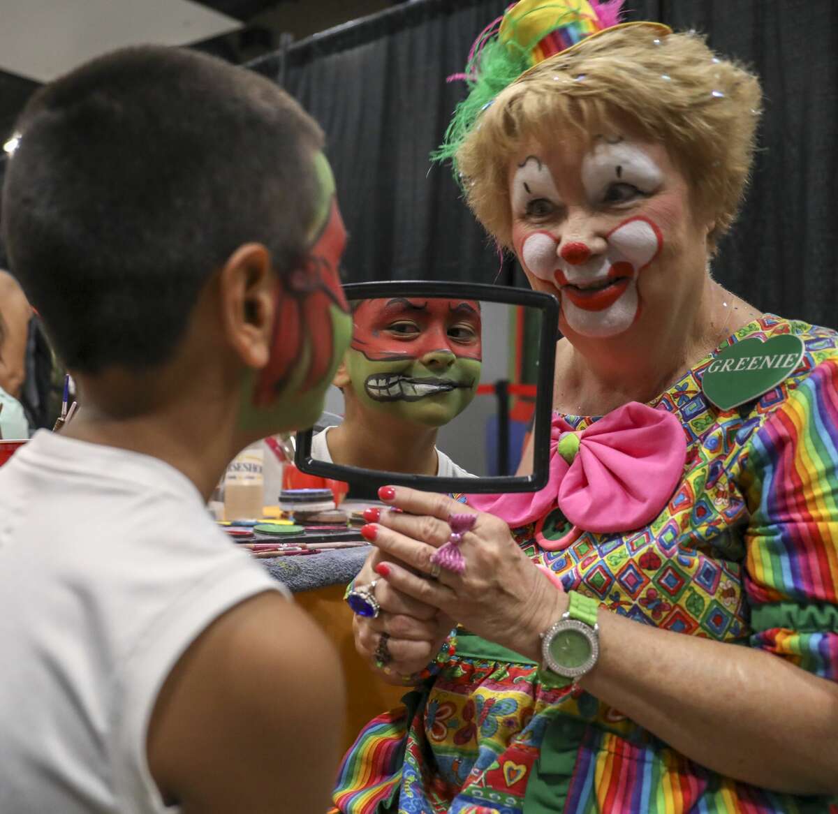 Greenie the Clown, Linda Greene, shows David Montez III his Mutant Ninja Turtle face paint during the Family Fun Day on Saturday, Aug. 10, 2019 at the Horseshoe Pavilion.