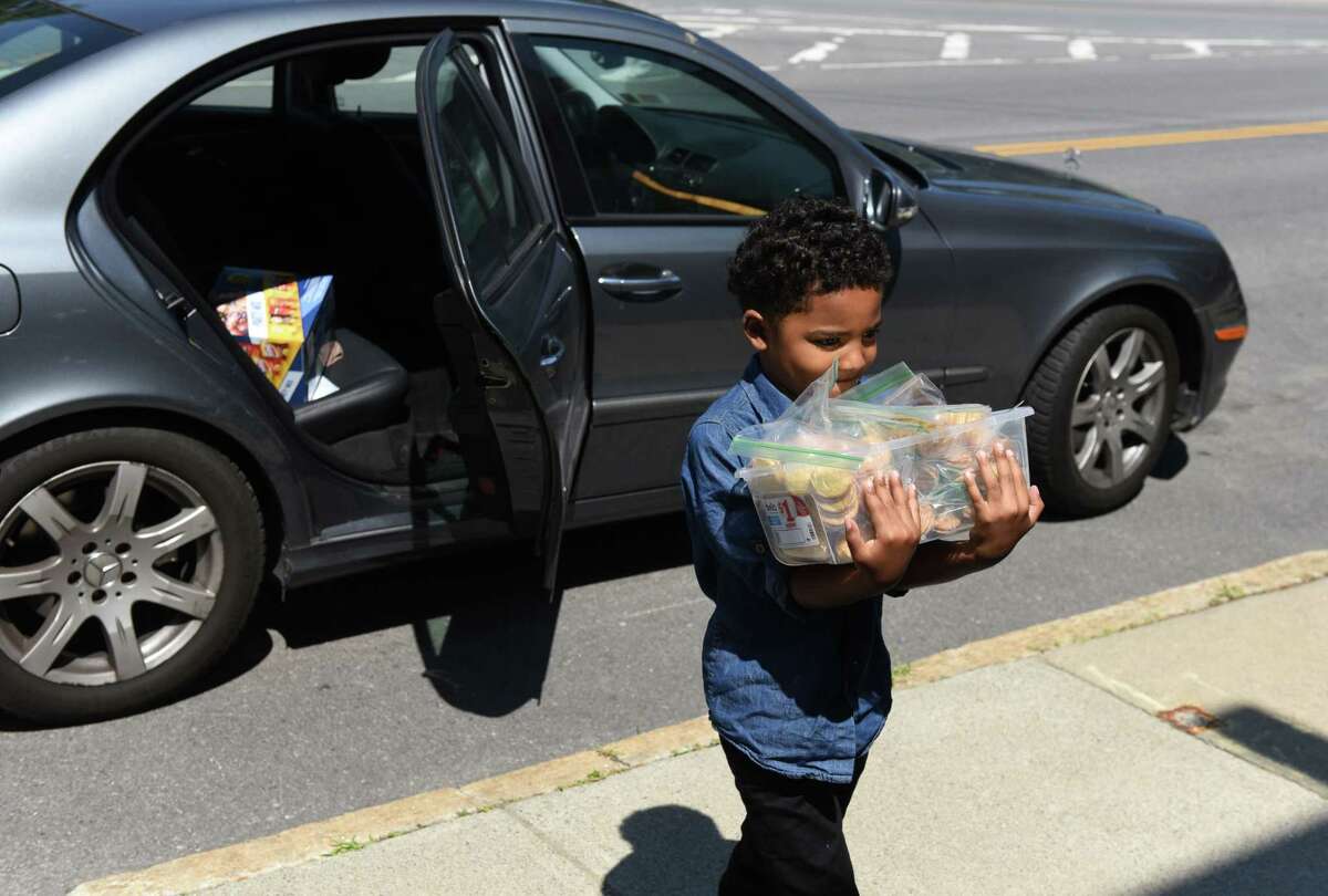 Malachi Houze, 5, delivers prepared meals to the Homeless Action Committee facility on Monday, Aug. 9, 2019, in Albany, N.Y. (Will Waldron/Times Union)