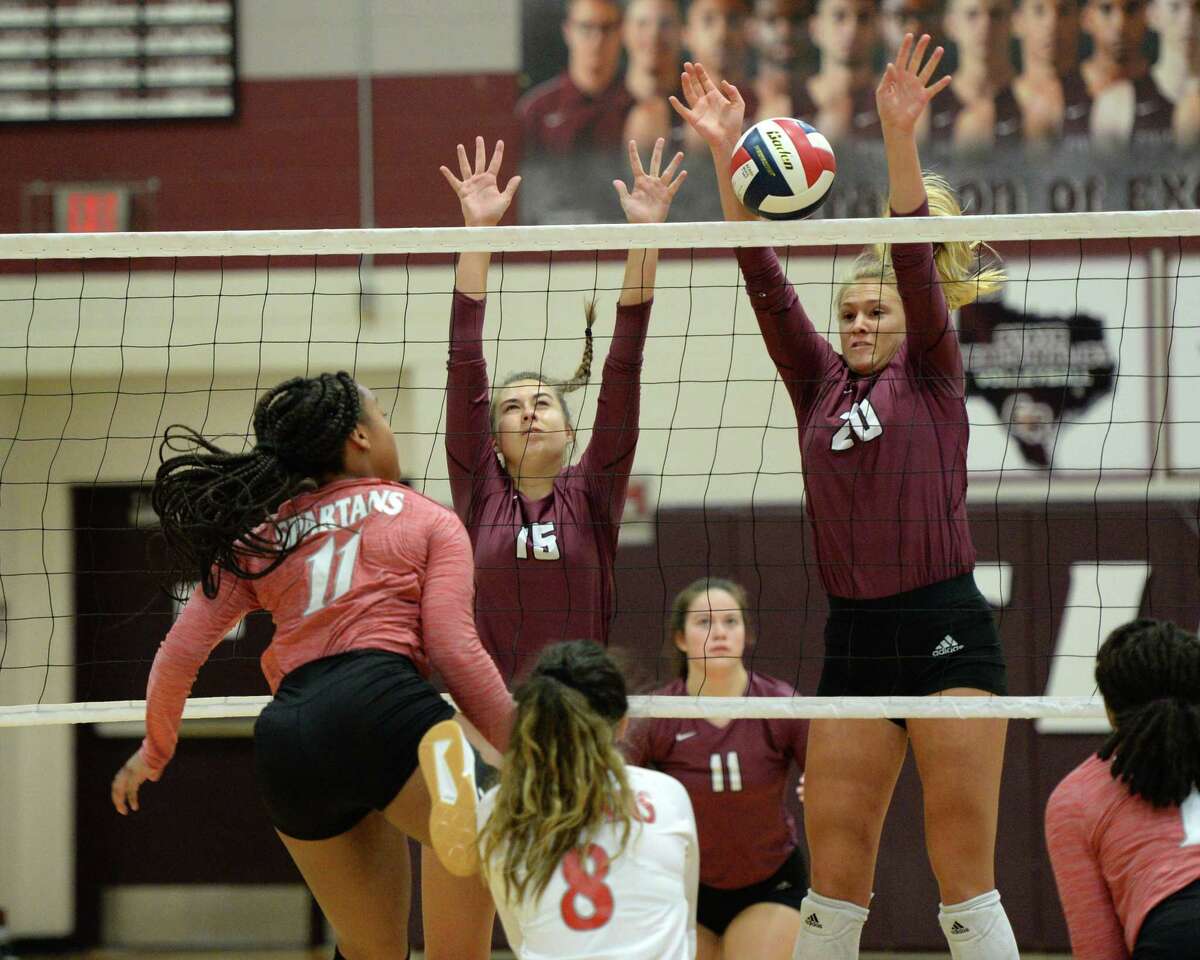 Haley Payne (15) and Madalyn O'Brien (20) of Cinco Ranch block a shot delivered by Jasmine Walker (11) of Cy Lakes during the first set of a volleyball match between the Cinco Ranch Cougars and the Cy Lakes Spartans on Friday, August 9, 2019 at Cinco Ranch HS, Katy, TX.