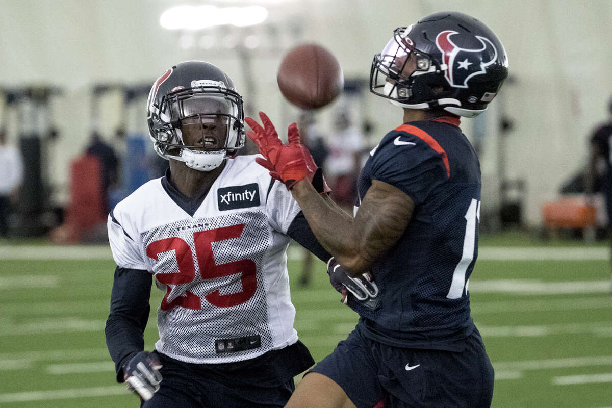 Houston Texans wide receiver Tyron Johnson (13) hauls in a reception with defensive back Deante Burton (25) defending during training camp at the Houston Methodist Training Center on Monday, Aug. 12, 2019, in Houston.