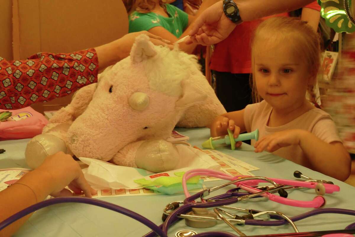 Corn-o the pink unicorn receives a check-up during Doc McStuffins stuffed animal clinic at RidgeCon on Saturday, Aug. 10.