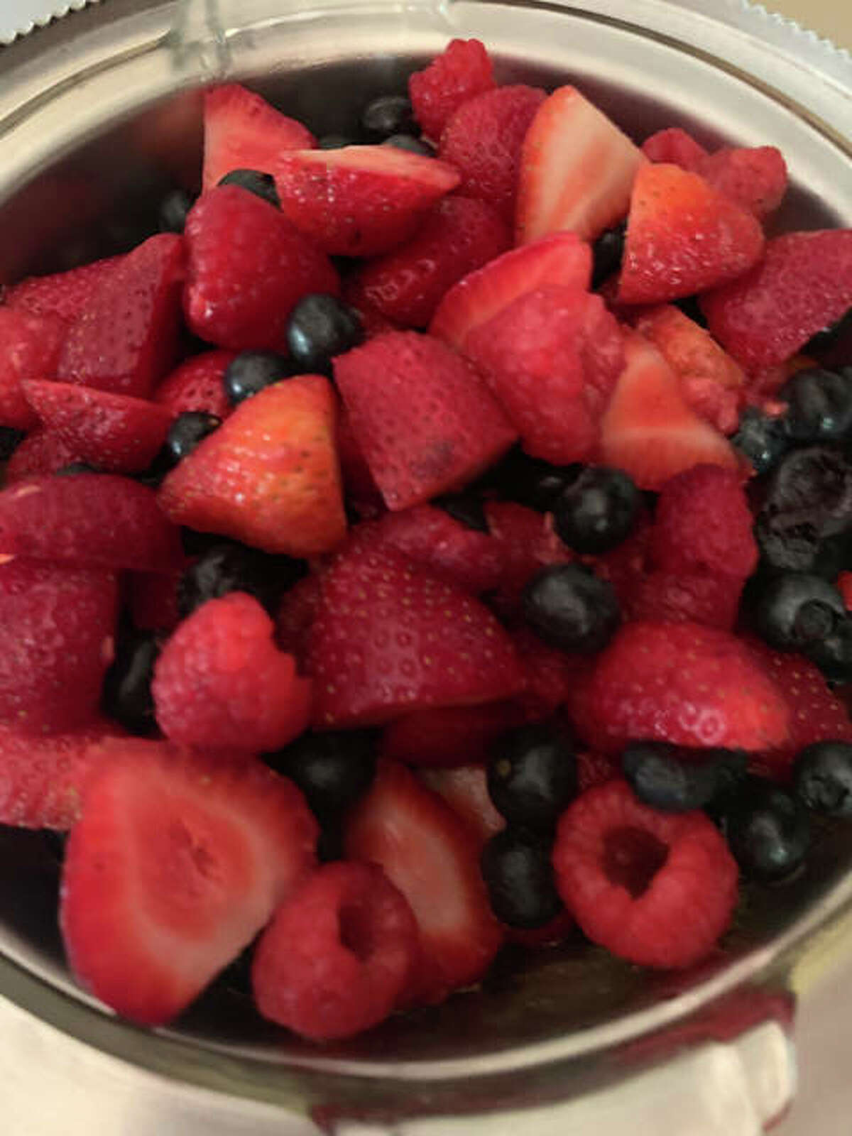 A side of seasonal fruit, with strawberries, raspberries and blueberries.