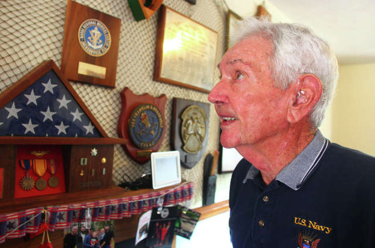 Alvin Marsh looks at one of his photos from his Navy days at his South Jacksonville home Aug. 7.