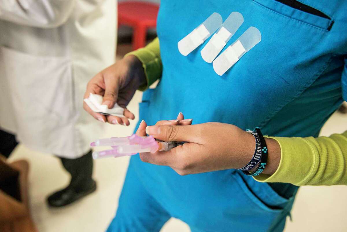 A certified medical assistant holds needles full of the HPV vaccination drug Gardasil before administering them to children at a community health center in Texas.