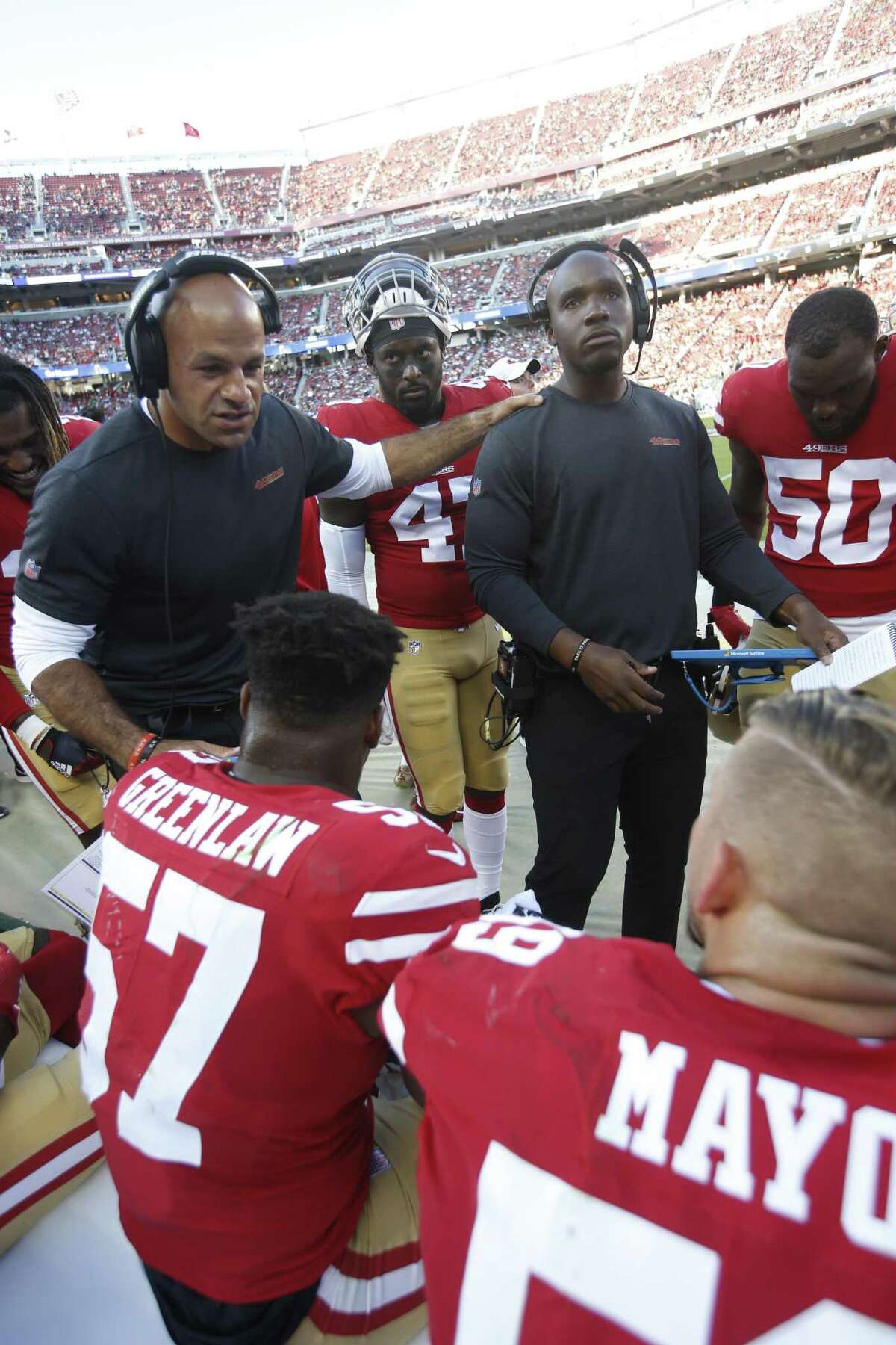 Defensive coordinator Robert Saleh and inside linebackers coach DeMeco Ryans of the San Francisco 49ers talk with the linebackers on the sideline during a preseason game.