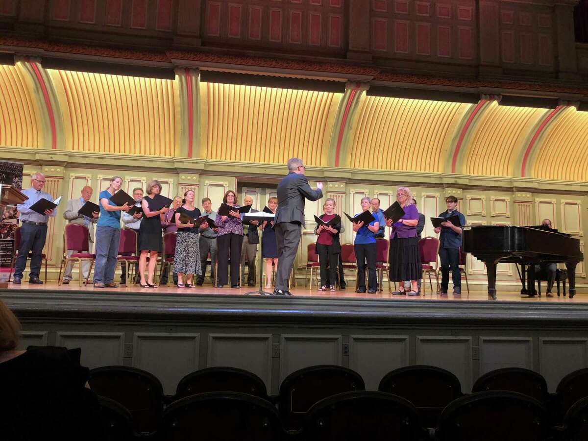 Jose Daniel Flores-Caraballo conducting Albany Pro Musica singers at a Troy Music Hall event announcing gifts to the ensemble (photo courtesy Overit Media / Albany Pro Musica)