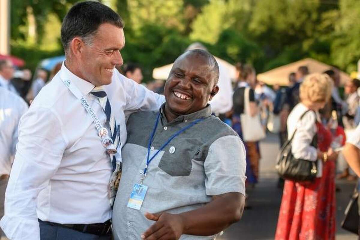 Wilfred Kimani, 47, of St. Louis greets a delegate visiting from England
