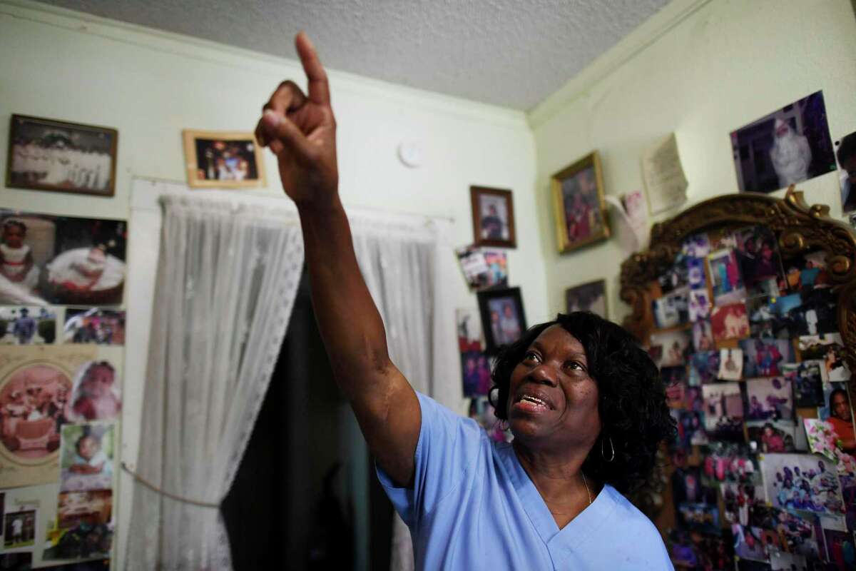 Marilyn Washington, who lives in East San Antonio, points to family photographs that adorn the walls in her home. She works as a home healthcare provider and has no access to paid sick leave. She has joined the lawsuit along with TOP/MOVE to defend the city's ordinance, which mandates businesses with six to 15 employees provide a minimum of 48 paid sick hours per year. Businesses with more than 15 employees are required to provide 64 paid sick hours per year.