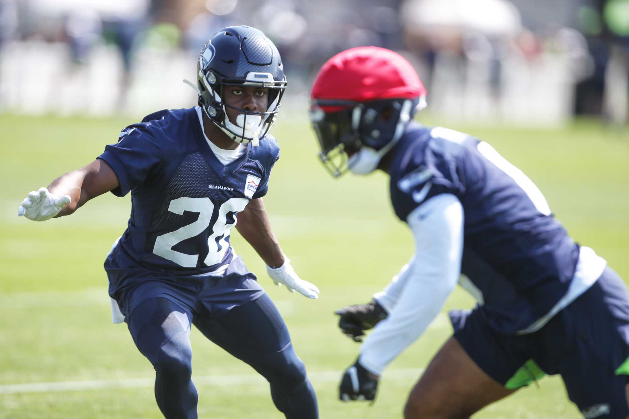 Seattle Seahawks wide receivers John Ursua (15) and Gary Jennings (11)  watch drills on the first