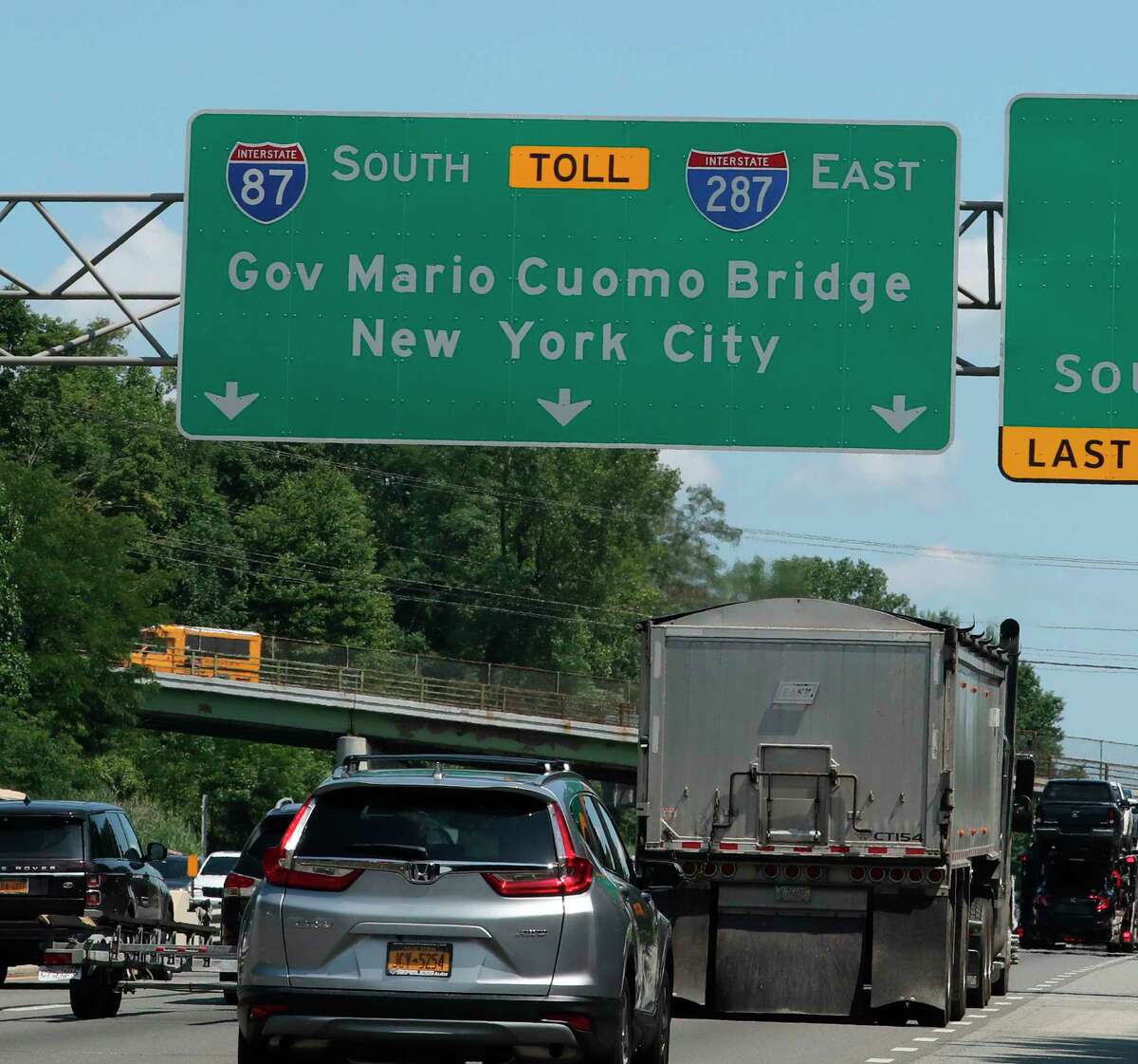 In this Aug. 1, 2019, photo, traffic passes under a sign for the Gov. Mario M. Cuomo Bridge on the New York State Thruway in Nyack, N.Y. The New York State Department of Transportation said Thursday, Aug. 15, 2019 that roughly year-old signs for the suburban bridge named after the former governor are being patched over because his middle initial is missing. (Peter Carr/The Journal News via AP)