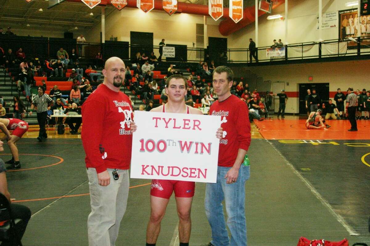 Tyler Wins: Senior Tyler Knudsen celebrates with his coaches after earning his 100th career victory on January 12. (Photo/Bryan Warrick)