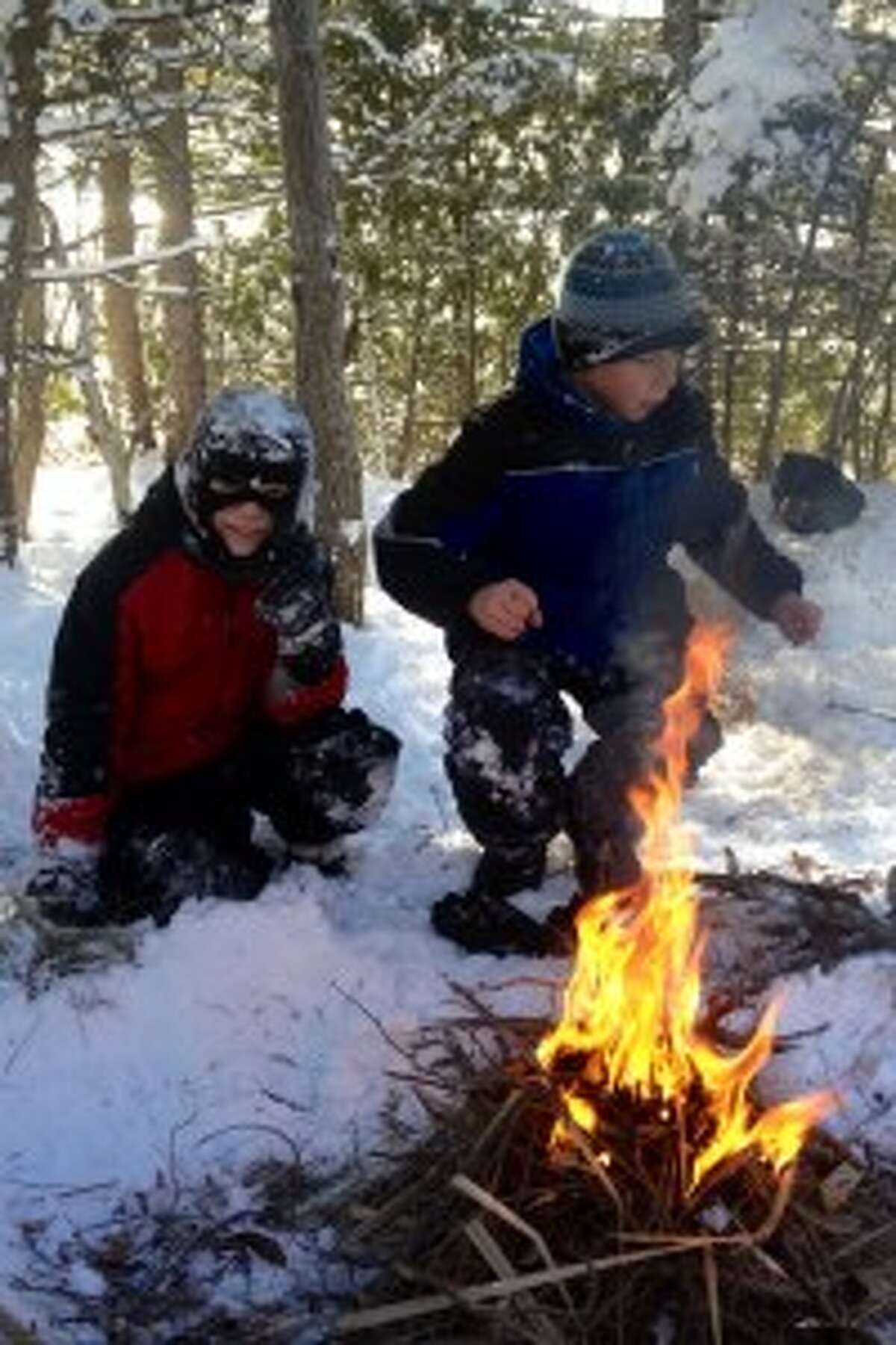 Staying warm: Jagger and Zach learn how to build a fire during survival training. Students were able to enjoy their fires by making s’mores.” Photos/Julie Mountz
