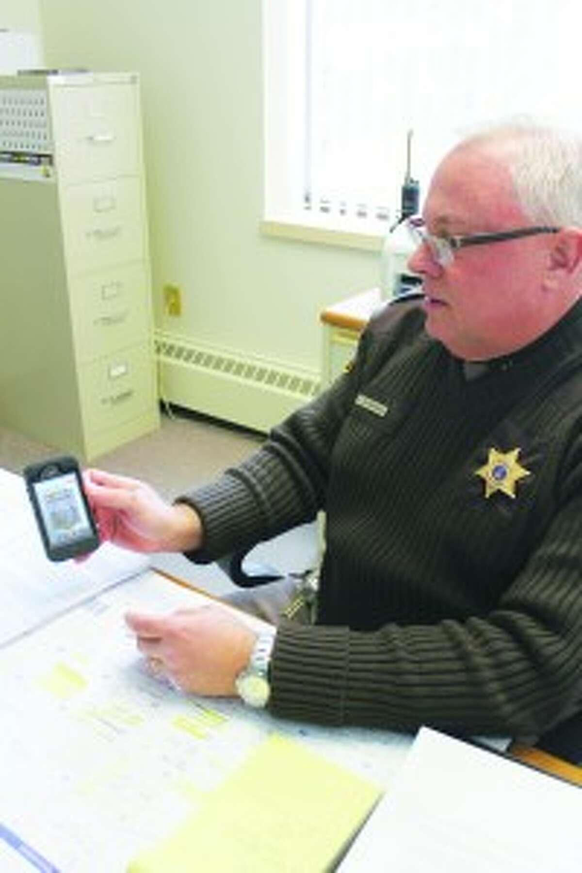 An App for That: Sheriff Ted Schendel shows off the latest tool Benzie County law enforcement has for getting in touch with residents; a smart phone application. (Photo/Colin Merry)