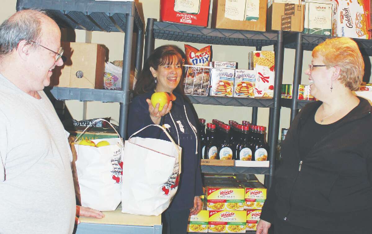 New in Town: Pastor Jan Nugent, Butch McKeen and Darlene Miank finish putting away a shipment of food for the Family Pantry; the newest food pantry in Benzie. Unlike other pantries, it will be open evenings for the convenience of working families. Photo/Colin Merry