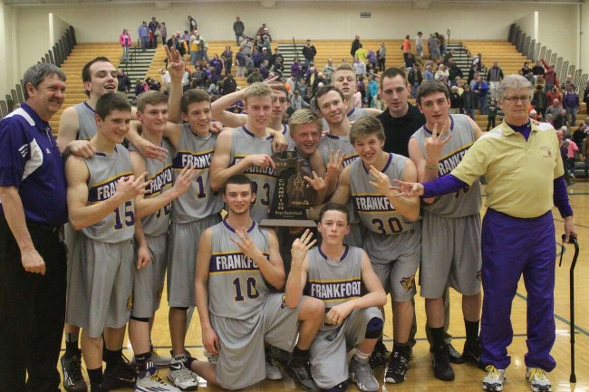 THREE-PEAT: The Frankfort boys hold up threes along with their trophy after winning their third straight Regional Championship title on March 18. The team defeated Boyne Falls in a close defensive battle. (Photos/Bryan Warrick)