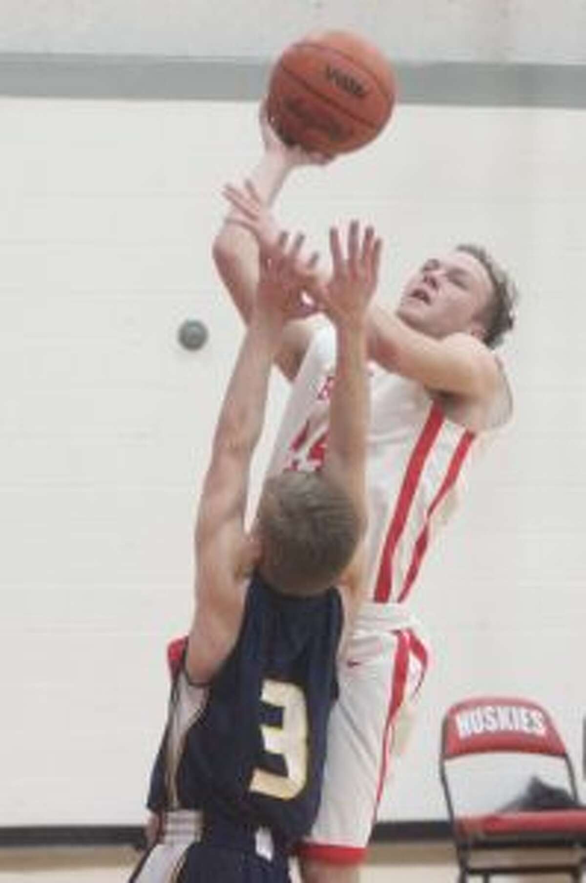 Chris Dunlop battles through contact for a layup during the Huskies JV loss to Cadillac. (Photo/Robert Myers)