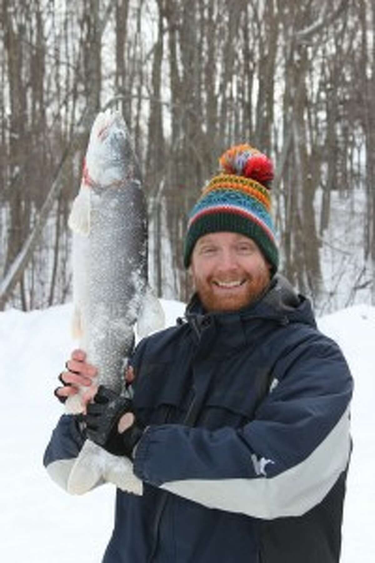 Jordan Bates wields the 8.2 pound lake trout he caught with fishing partner Alex Brydges.