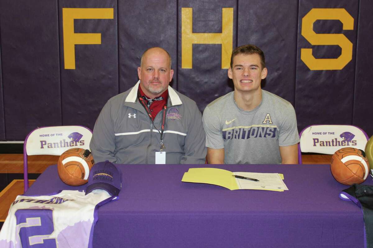 Conner Smith celebrates signing his letter of intent to play football for Albion with his high school coach Matt Stapleton. (Photo/Robert Myers)