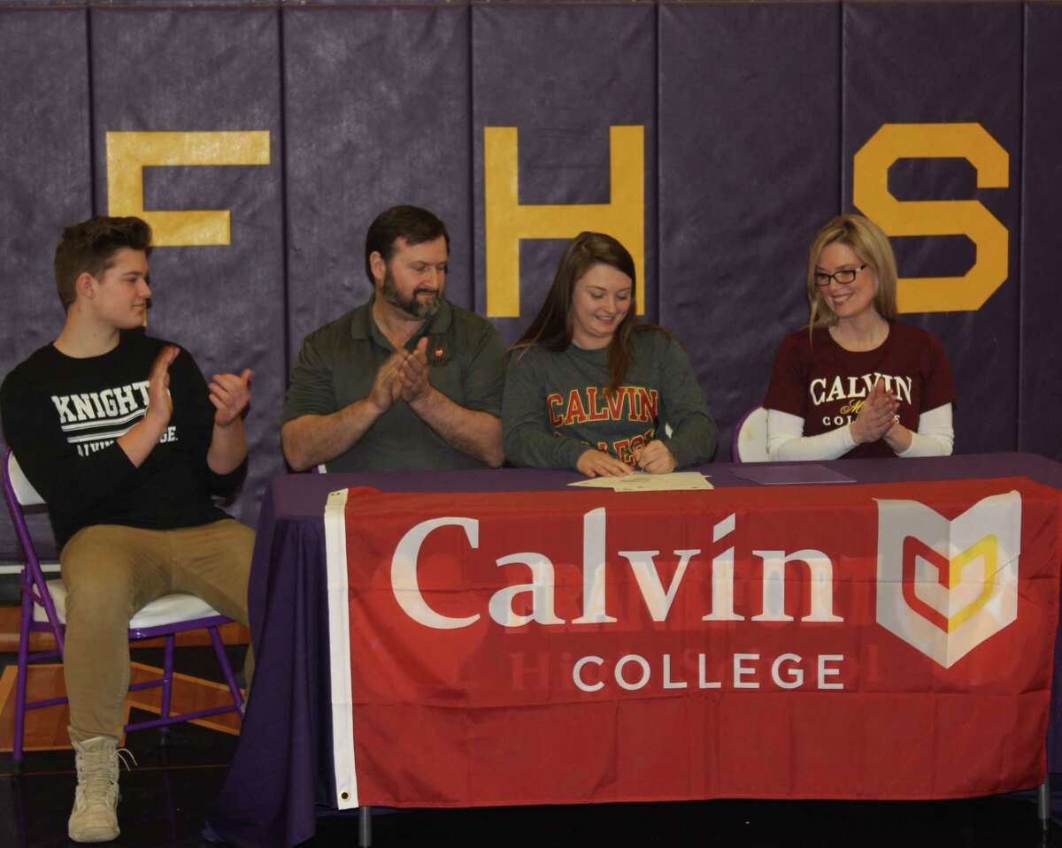 Surrounded by her family, Frankfort senior Natalie Bigley signs her letter of intent to play college softball for Calvin College. (Photo/Robert Myers)