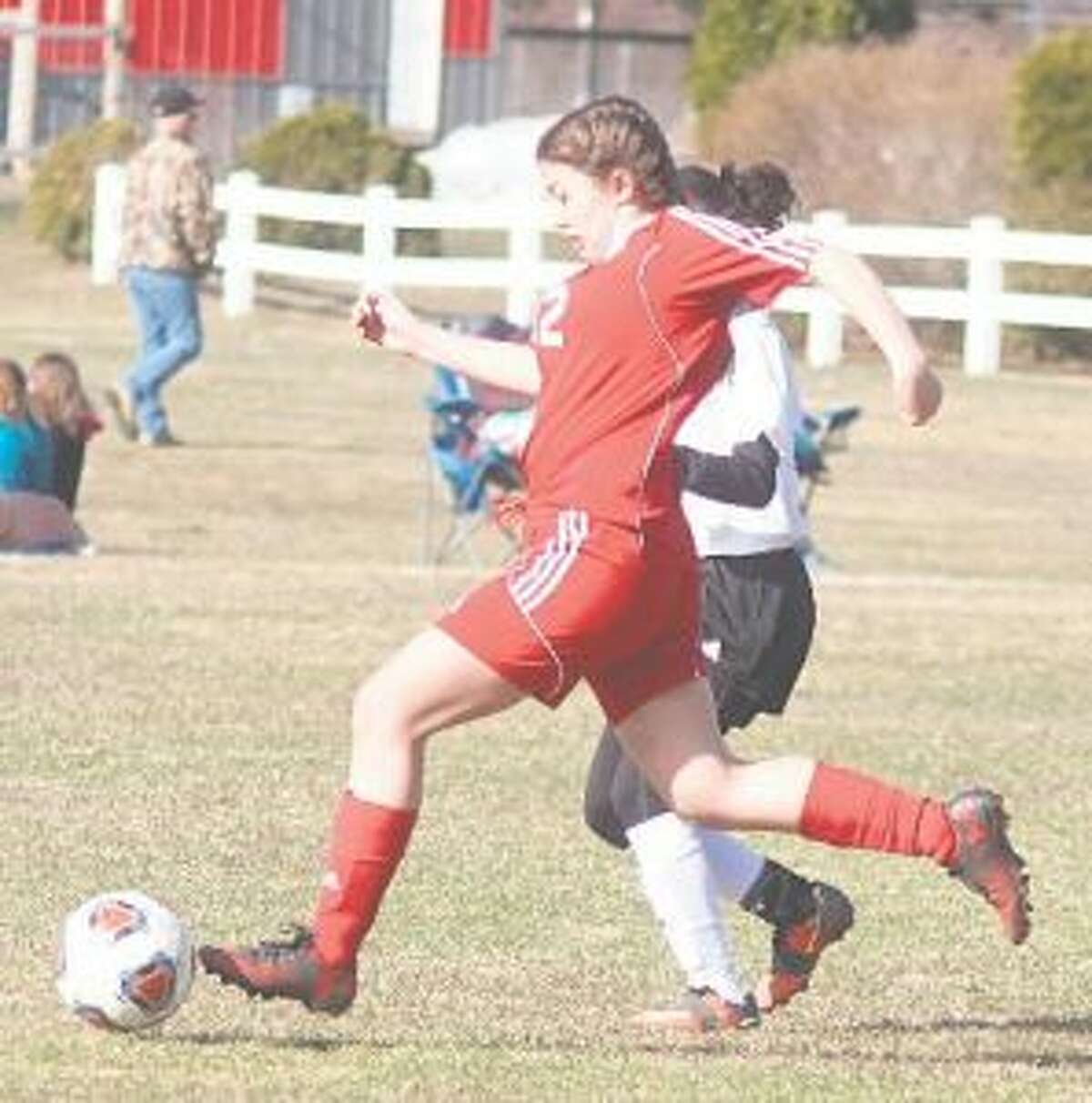 Isabel Pataky (12) battles to clear the ball from the defensive end. (Photo/Robert Myers)