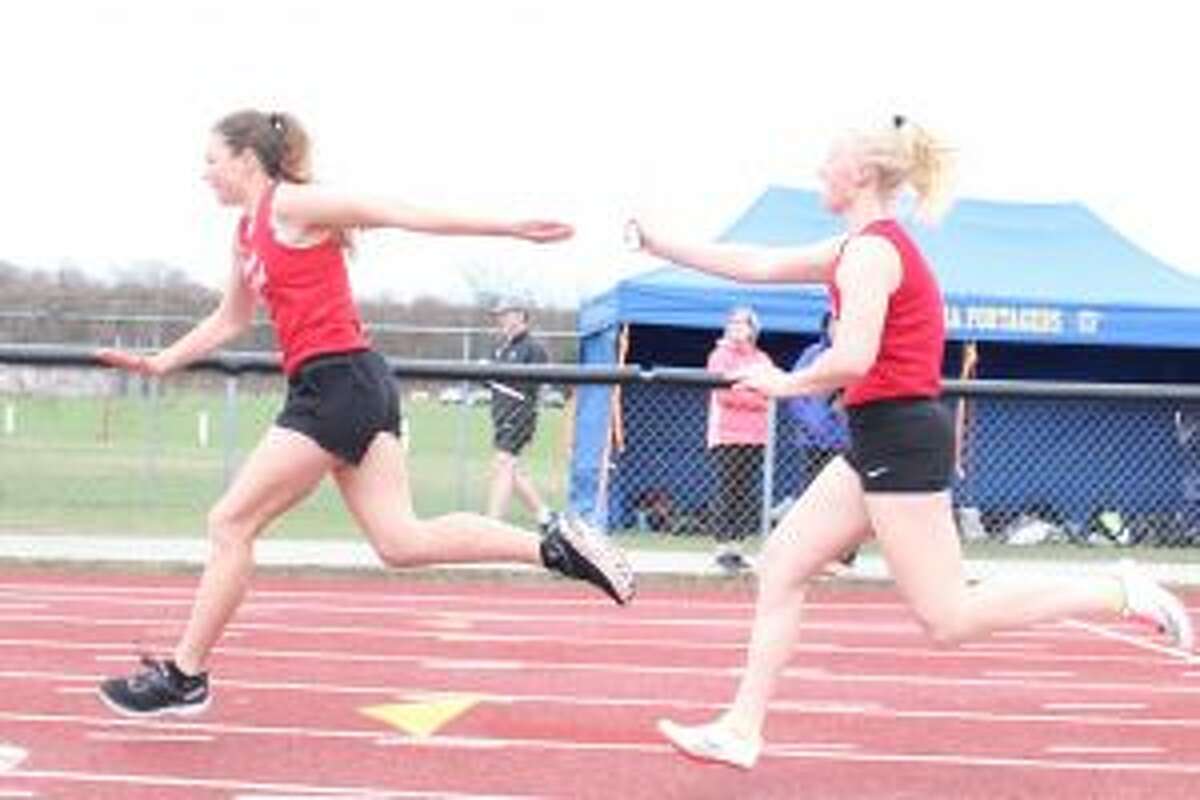 Thea Gray hands off to Bella Huddleston in the senior 4x100-meter relay. (Photo/Robert Myers)