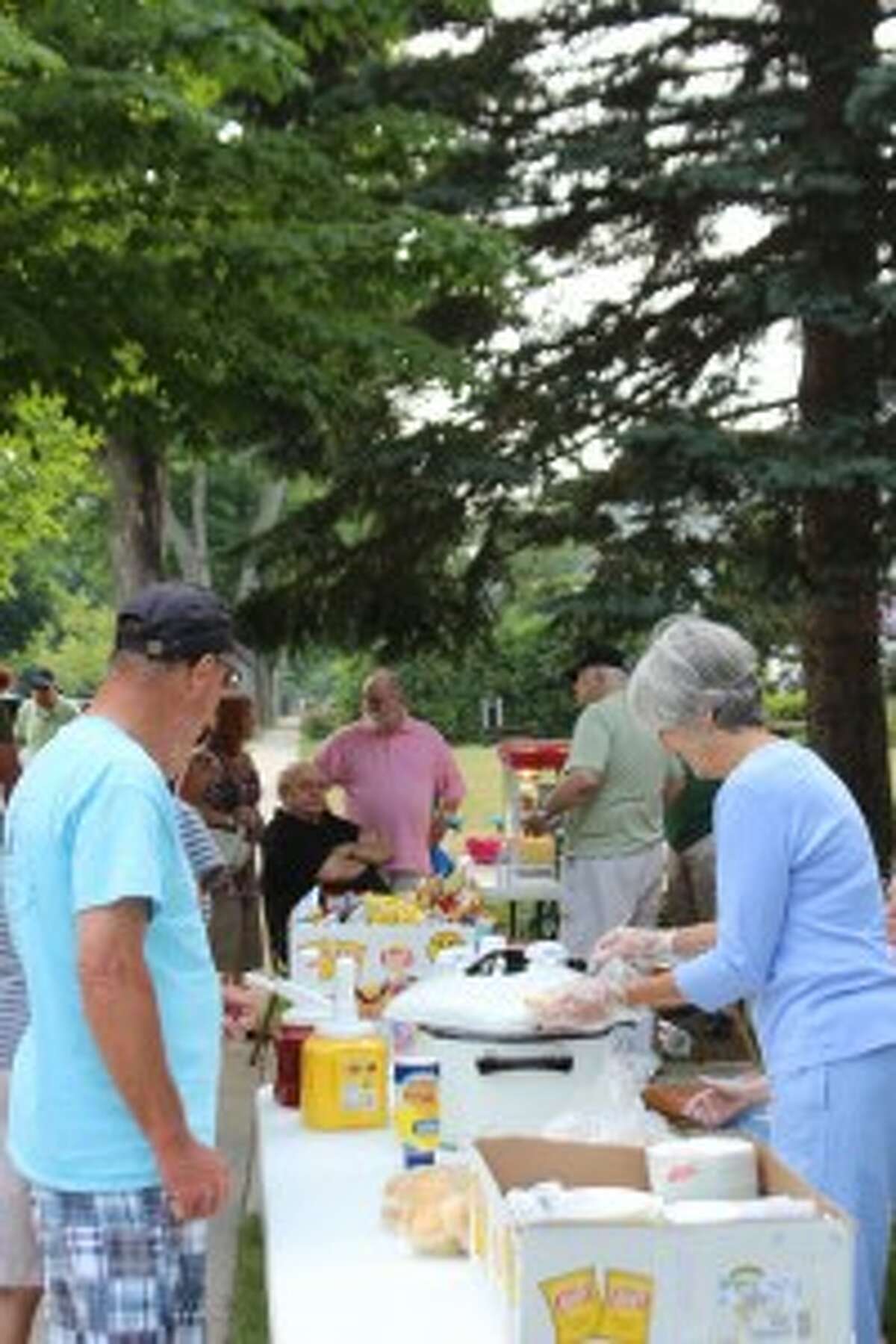 FEED THE SOUL: Hungry visitors and members of the First Congregational Church of Frankfort congregation line up to get a free picnic dinner during the church's Block Party, held July 22. (Photo/Colin Merry)