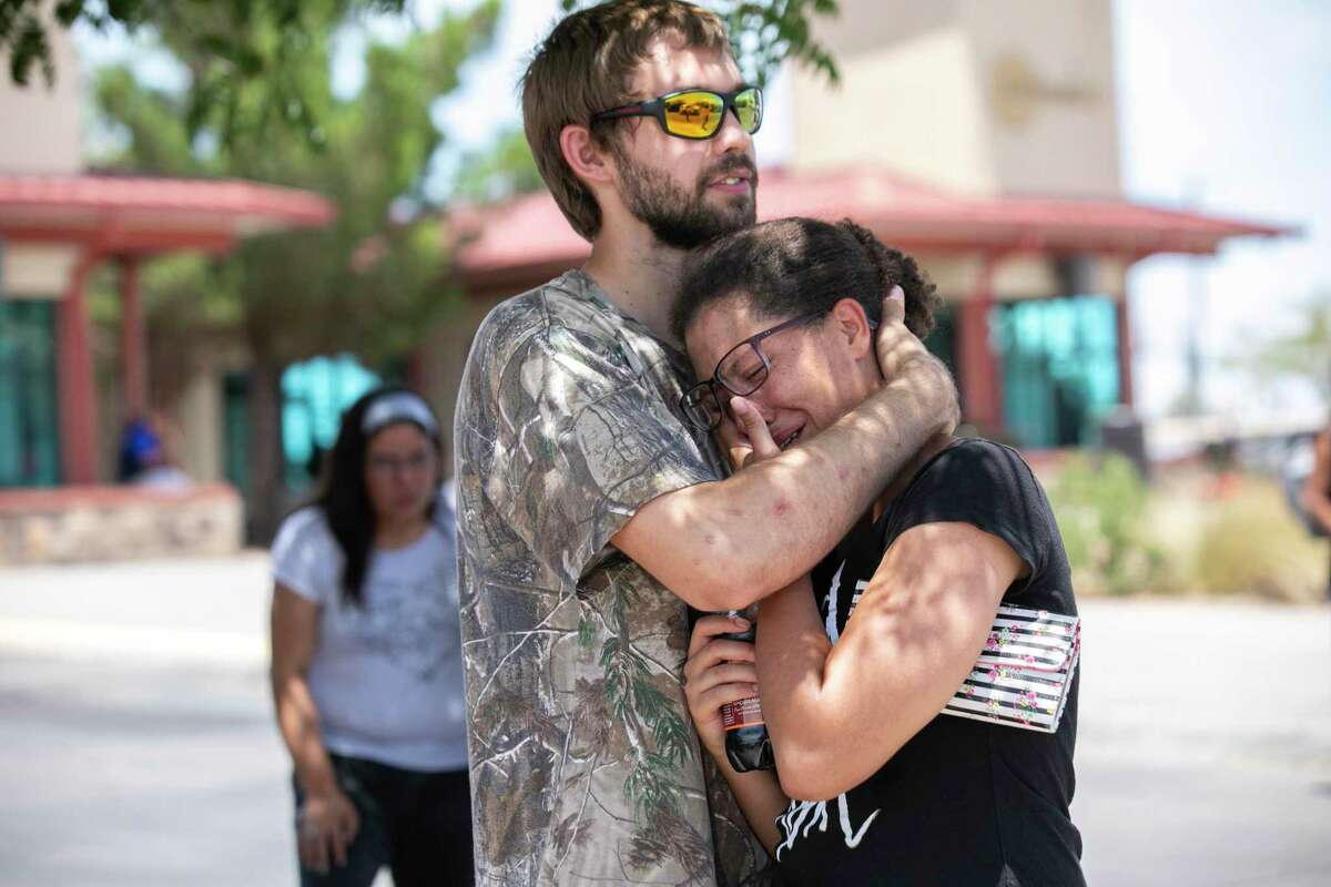 Kianna Long and husband Kendall Long embrace near the Walmart where a man opened fire on back-to-school shoppers, Saturday, August 3, 2019, in El Paso, Texas. The couple were both inside the Walmart when the shooting started. They were in the freezer section and ran outside and hid inside storage containers with other people until helped arrived.
