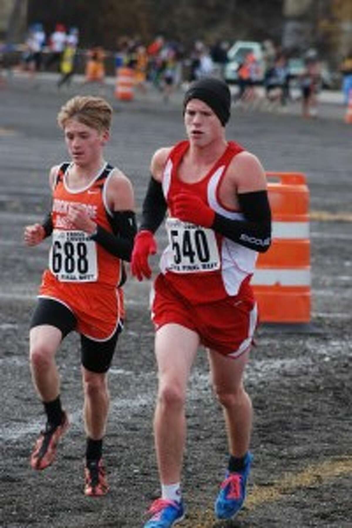 RUNNING THROUGH THE COLD: Benzie Central runner Jake Williams (right) helped the Huskies clinch a second straight state title at the Michigan International Speedway.